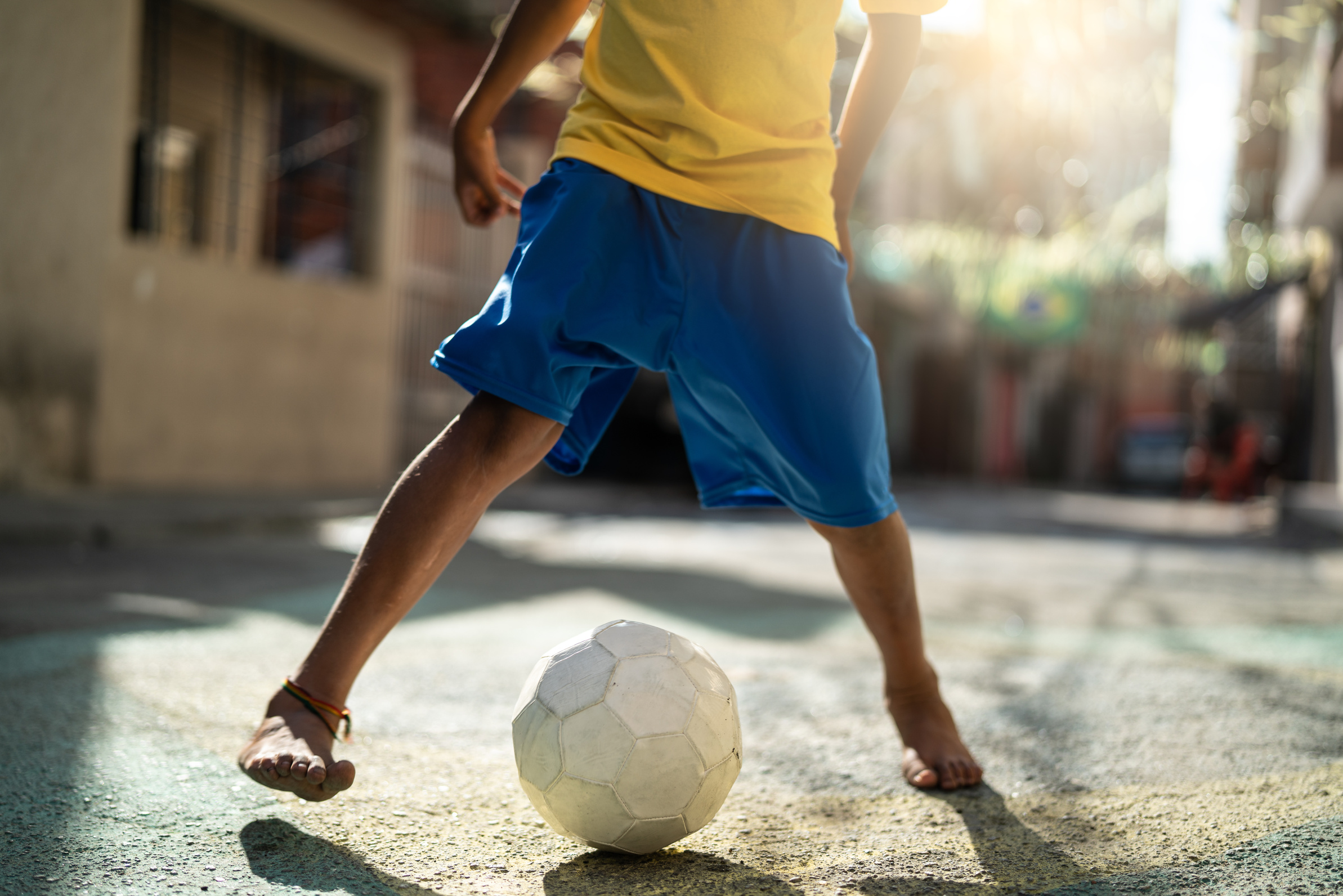 Brazilian Kid Playing Soccer in the Street